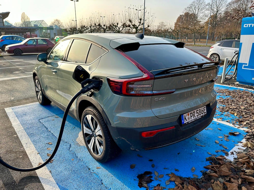 Blick auf das Heck des Volvo C40 Recharge mit angeschlossenem Ladekabel.