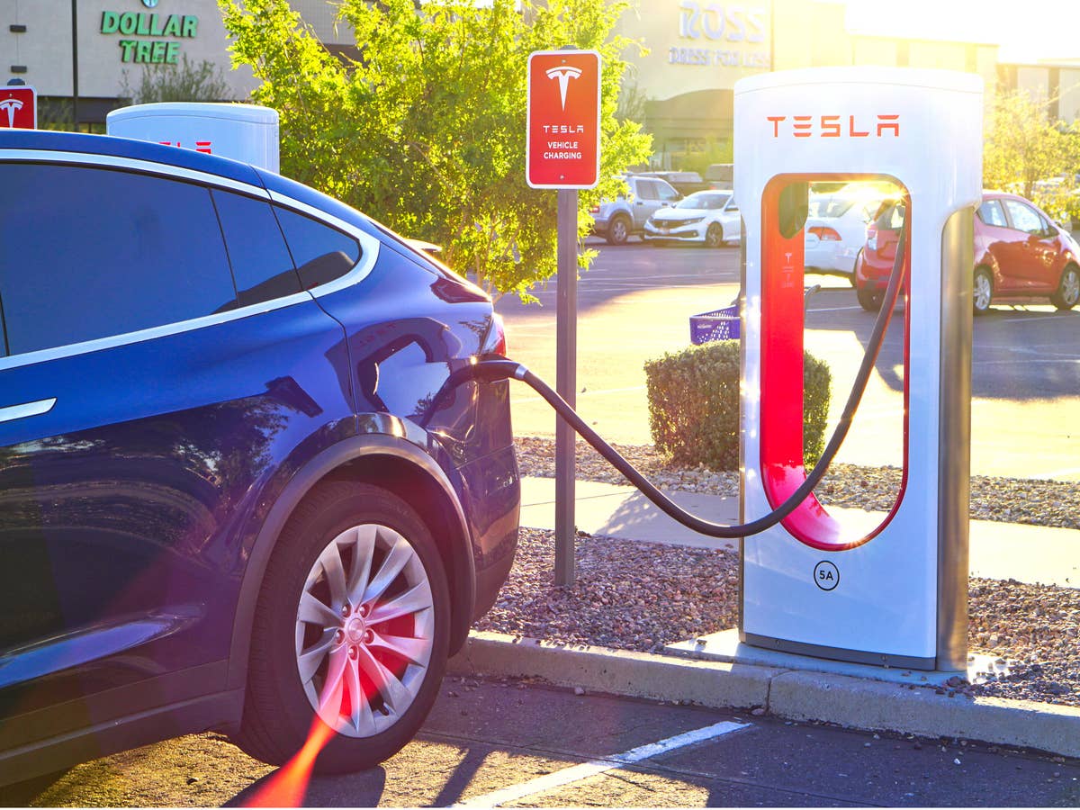 Tesla steht an einer Ladesäule.