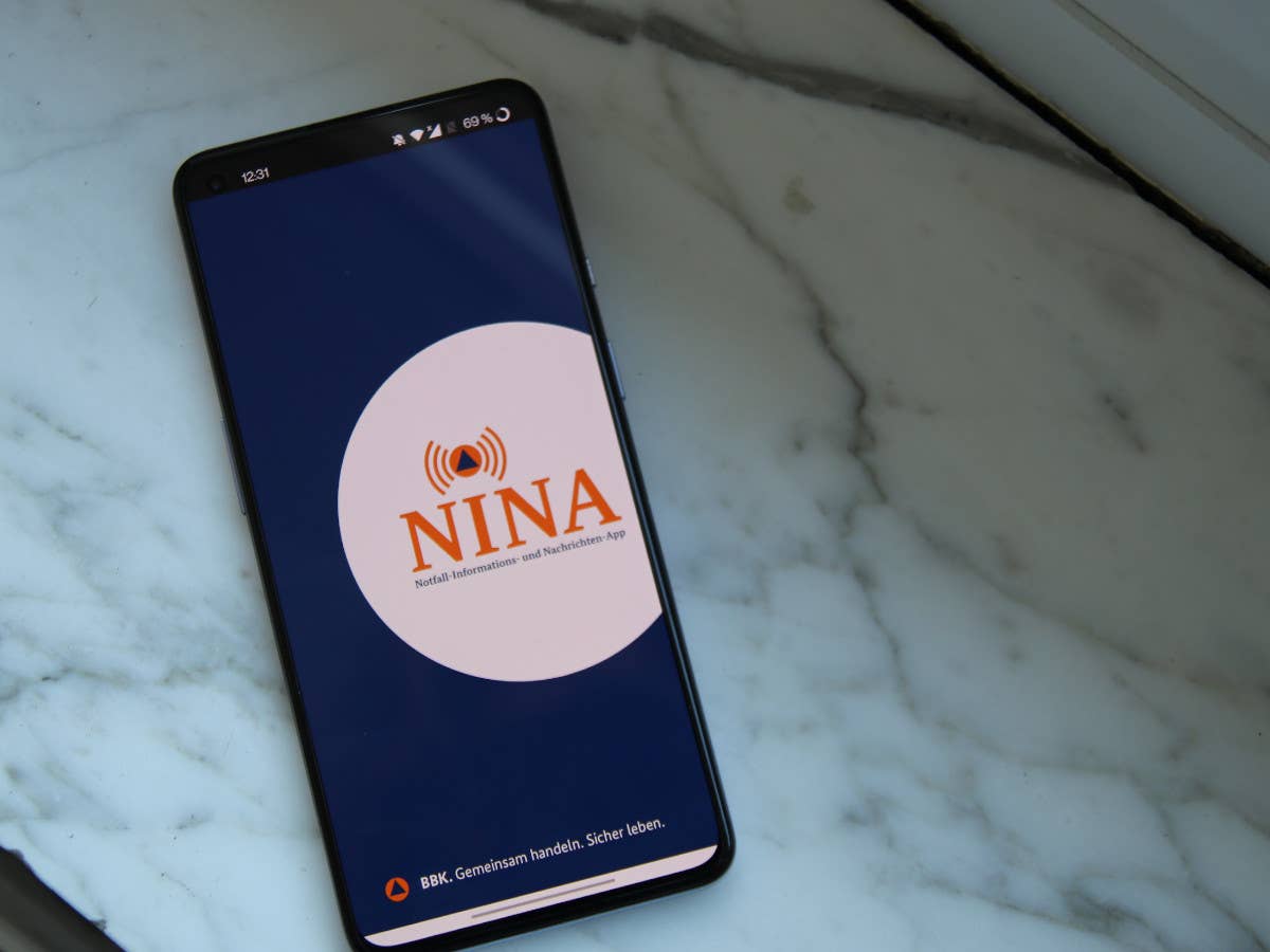 Die Warn-App NINA auf einem Smartphone vor Marmor-Hintergrund.