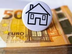 Euroschein mit Hausbutton darüber, Sinnbild für Miete