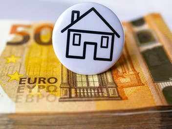 Euroschein mit Hausbutton darüber, Sinnbild für Miete