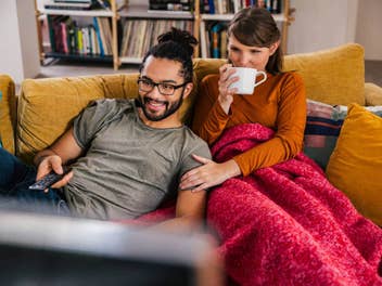 Mann und Frau nutzen Magenta TV von der Telekom auf einem Sofa