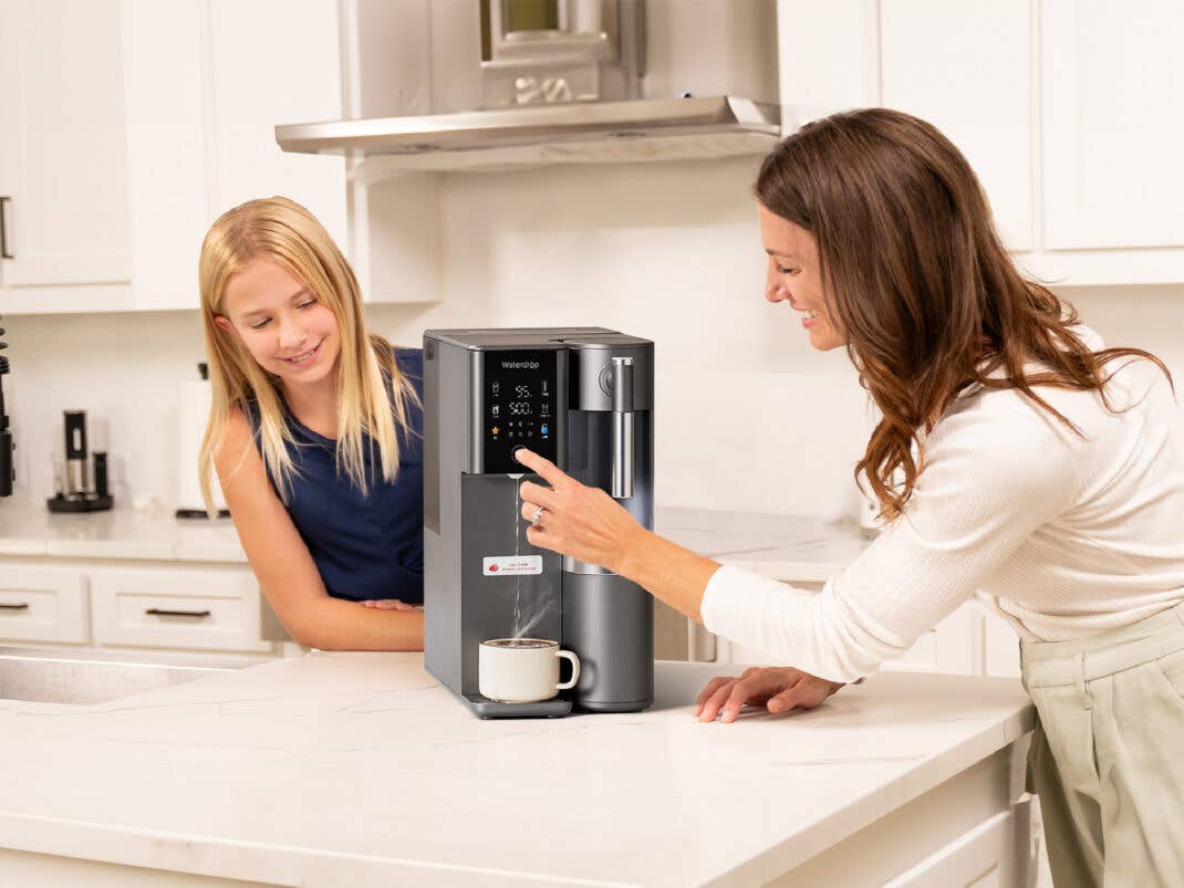 Zwei Personen bedienen einen Wasserfilter von Waterdrop.