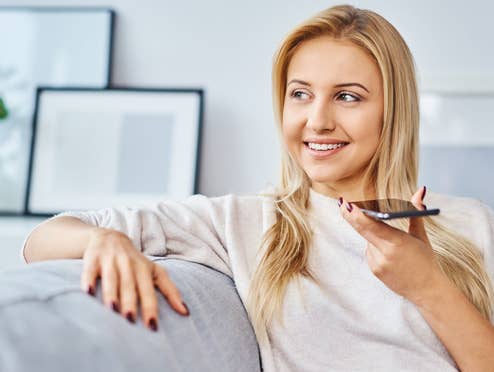 Weibliche Person telefoniert auf der Couch