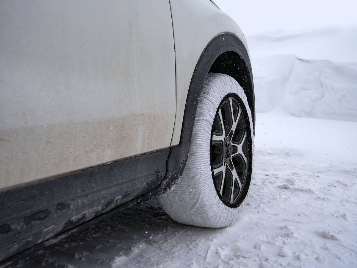 Ein Auto mit weißen Schneesocken auf schneebedecktem Grund