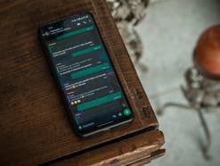 WhatsApp Chat auf einem Smartphone, das auf einem Holztisch liegt