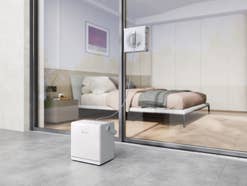Der WINBOT W2S PRO OMNI beim Einsatz am Schlafzimmerfenster mit Blick auf das Bett.