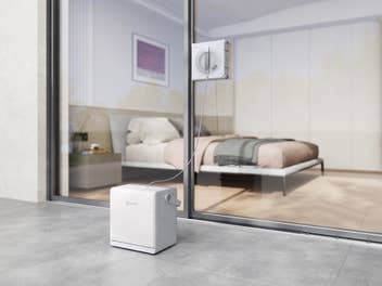 Der WINBOT W2S PRO OMNI beim Einsatz am Schlafzimmerfenster mit Blick auf das Bett.