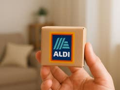 Winziges Aldi-Paket wird von einer Person in die Kamera gehalten