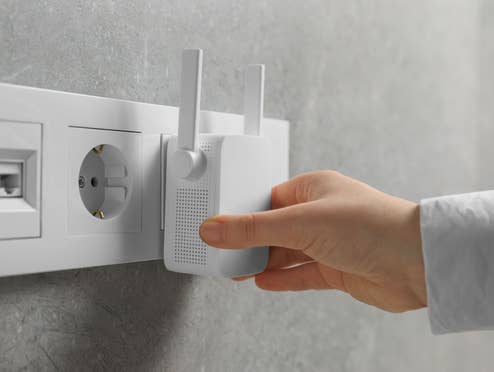 Ein WLAN-Repeater wird in eine Steckdose gesteckt