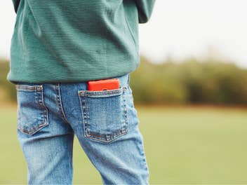 XploraOne Handy in der Hosentasche eines Kindes.