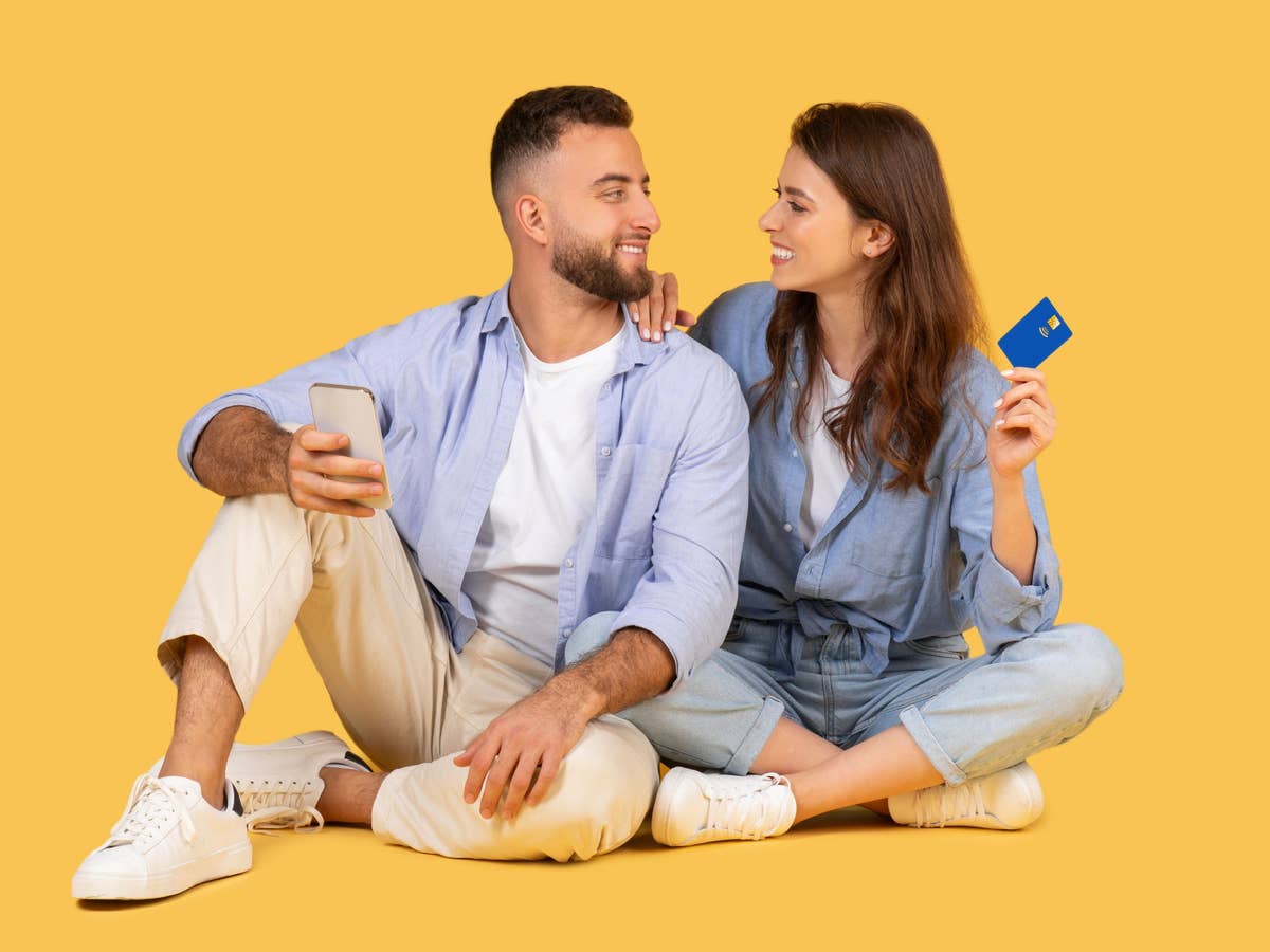 Flex-Tarif mit 70 GB: Zwei Optionen, welche sich mehr lohnt Zwei Personen schauen sich an, der Mann hält ein Smartphone, die Frau eine Kredikarte